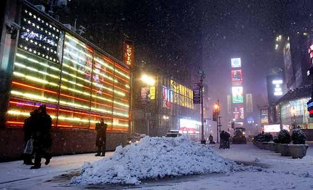 La gent camina per Times Square durant una tempesta de neu a Nova York (Estats Units).