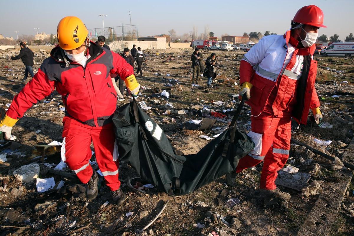Shahriar (Iran (islamic Republic Of)), 08/01/2020.- Members of the International Red Crescent collect bodies of victims around the wreckage after an Ukraine International Airlines Boeing 737-800 carrying 176 people crashed near Imam Khomeini Airport in Tehran, killing everyone on board, in Shahriar, Iran, 08 January 2020. (Ucrania, Teherán) EFE/EPA/ABEDIN TAHERKENAREH