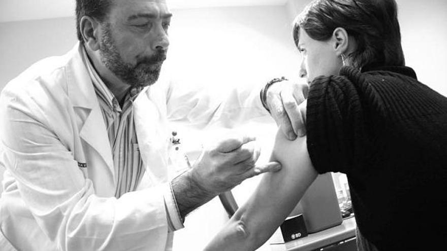 Jacinto López, del centro de salud de Montevil (Gijón), administra a Montserrat Cuervo la vacuna de la gripe A.