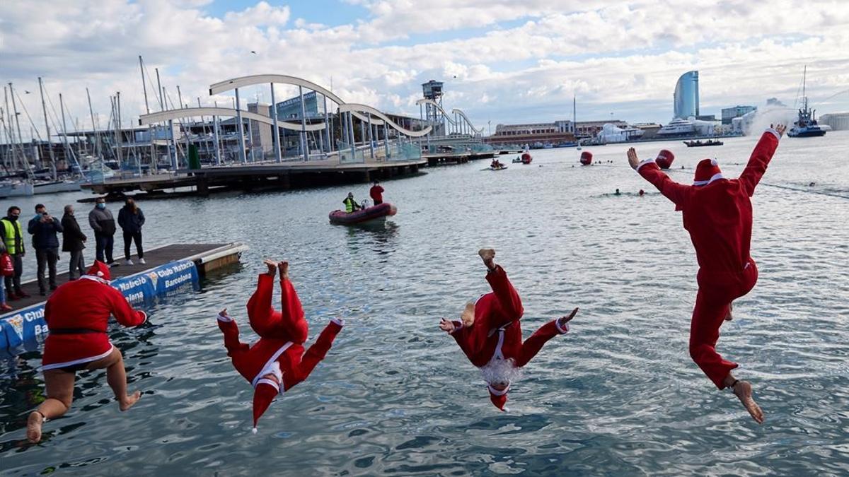 BARCELONA  25 12 2020 -Varios participantes disfrazados de Papa Noel se lanzan al agua para participar en la 111  edicion de la Copa Nadal  que este ano se celebra rodeada de medidas sanitarias a causa de la pandemia de COVID-19  este viernes  en Barcelona  EFE Alejandro Garcia