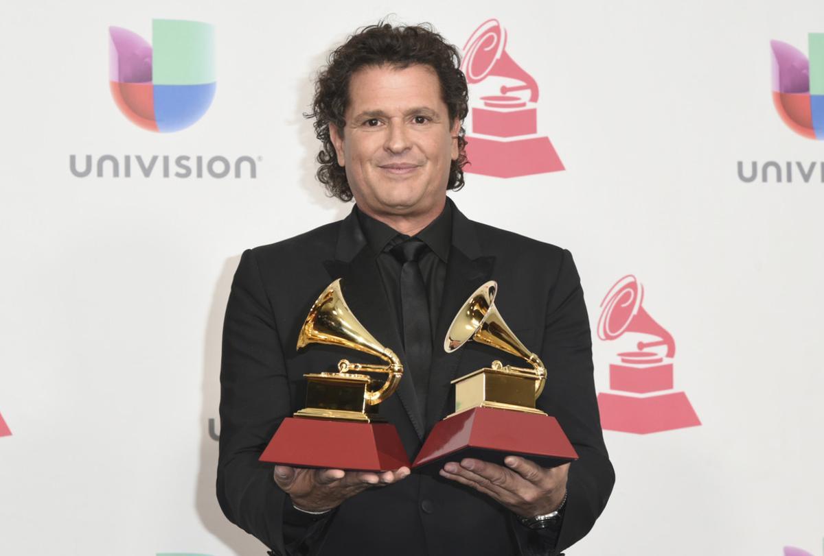 Carlos Vives poses in the press room with the awards for record of the year and song of the year for La Bicicleta at the 17th annual Latin Grammy Awards at the T-Mobile Arena on Thursday, Nov. 17, 2016, in Las Vegas. (Photo by Richard Shotwell/Invision/AP)