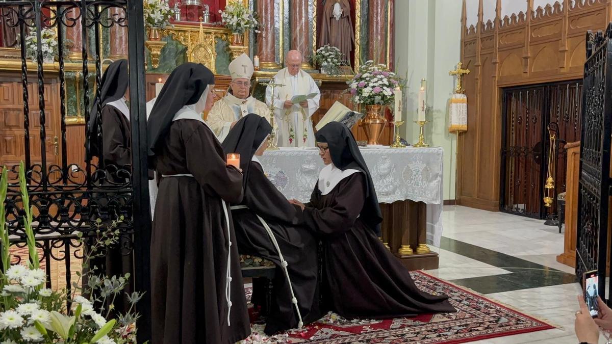 La nueva hermana Clarisa Descalza, sor María Rocío, de rodillas profesa sus votos a la madre abadesa ante el arzobispo de Mérida-Badajoz, José Rodríguez Carballo.