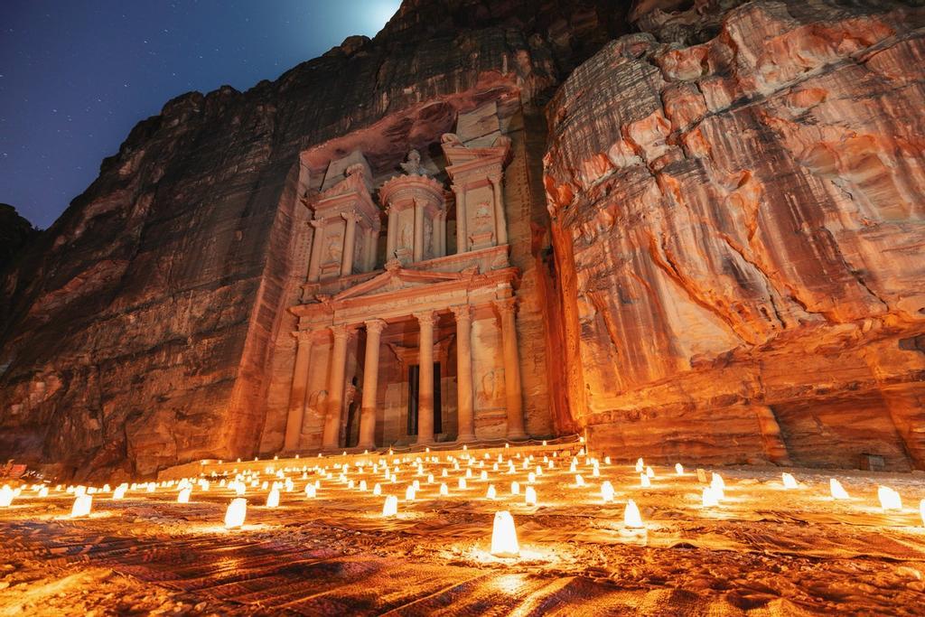 Petra iluminada por las cientos de velas que te acompañan por las noches y con la luna asomando por arriba