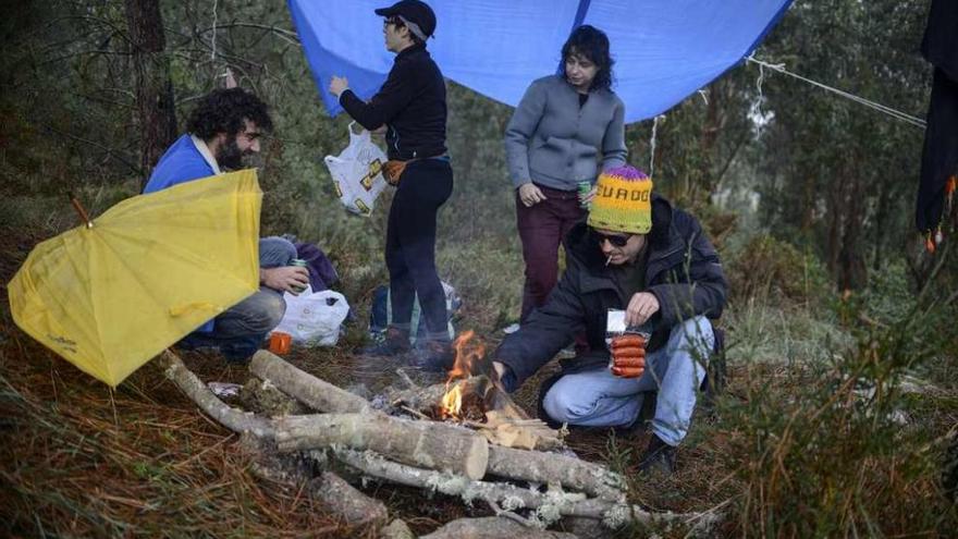 Un grupo de amigos prepara una hoguera para hacer un magosto en el monte. // Brais Lorenzo