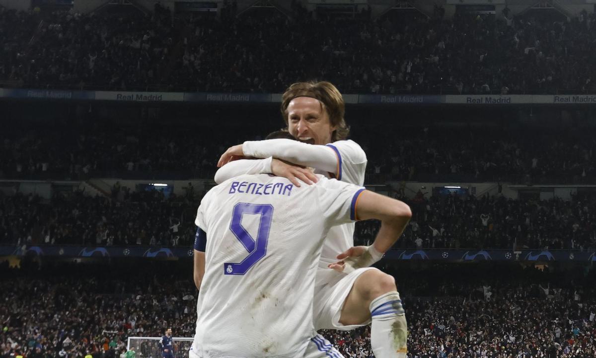 MADRID, 09/03/2022.- El delantero francés del Real Madrid Karim Benzema (de espaldas) celebra con Luka Modric el pase del equipo blanco a los cuartos de final de la Liga de Campeones tras derrotar al PSG en el encuentro disputado hoy miércoles en el estadio Santiago Bernabéu, en Madrid. EFE/Juanjo Martín.