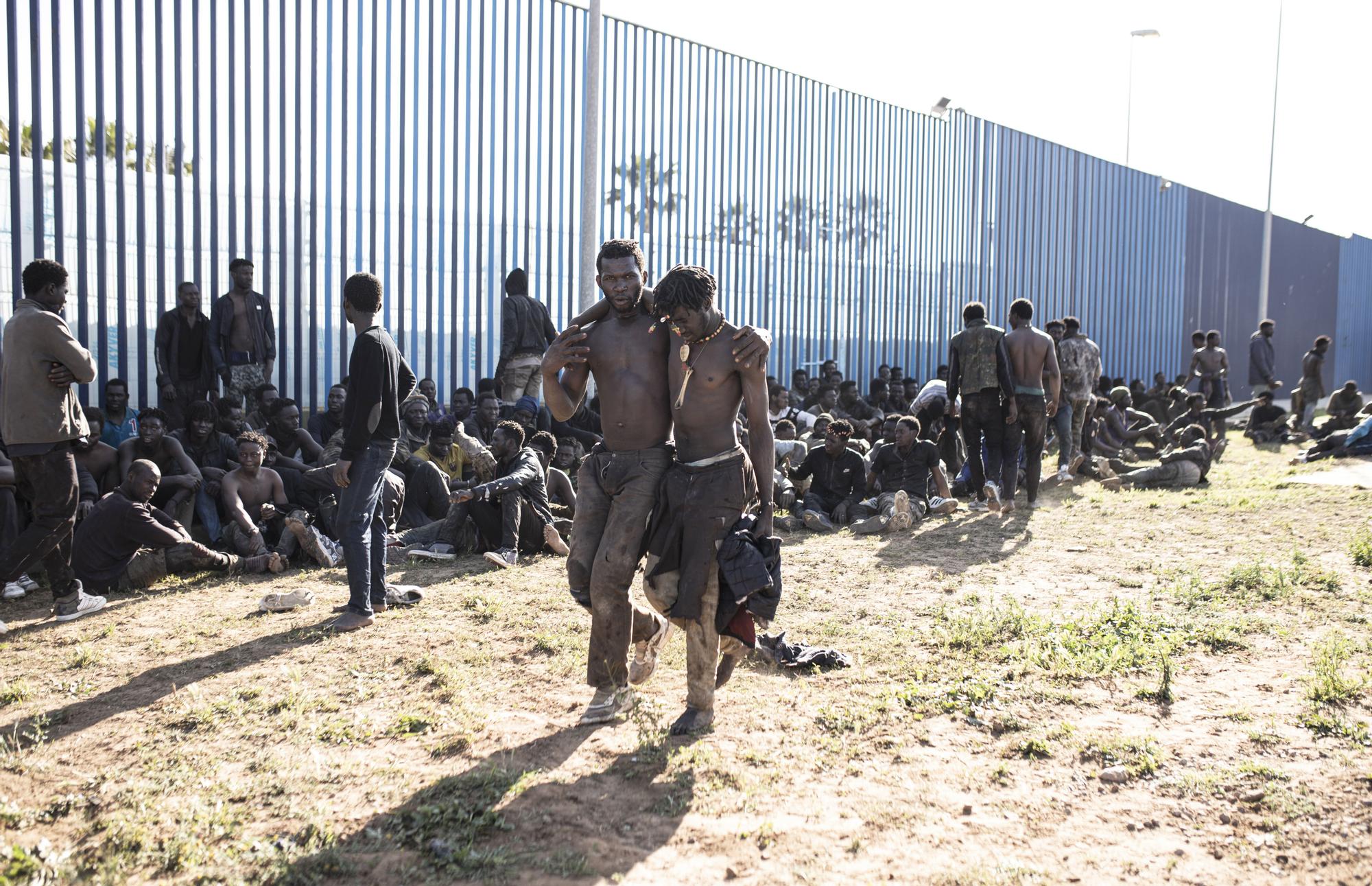 Migrantes al lado de la valla de Melilla.