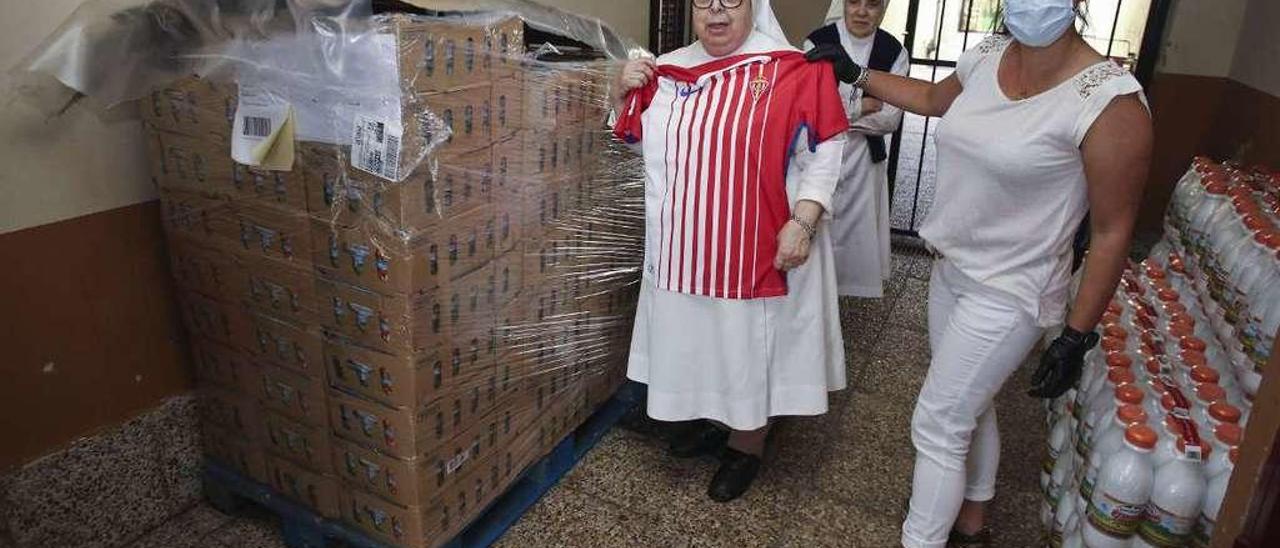 Carmen Álvarez, Milagros González y Alnair Vivanco, en la entrega de más de 400 litros de leche el pasado miércoles en la Congregación de las Siervas de Jesús de la Caridad, junto al obsequio de una camiseta del Sporting para las religiosas.