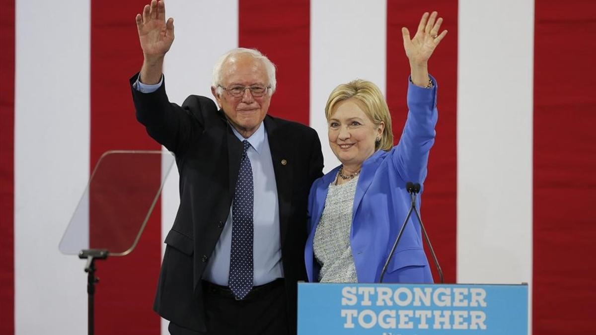 Sanders y Clinton saludan juntos a la audiencia del acto celebrado en Portsmouth (Nuevo Hampshire), este martes.