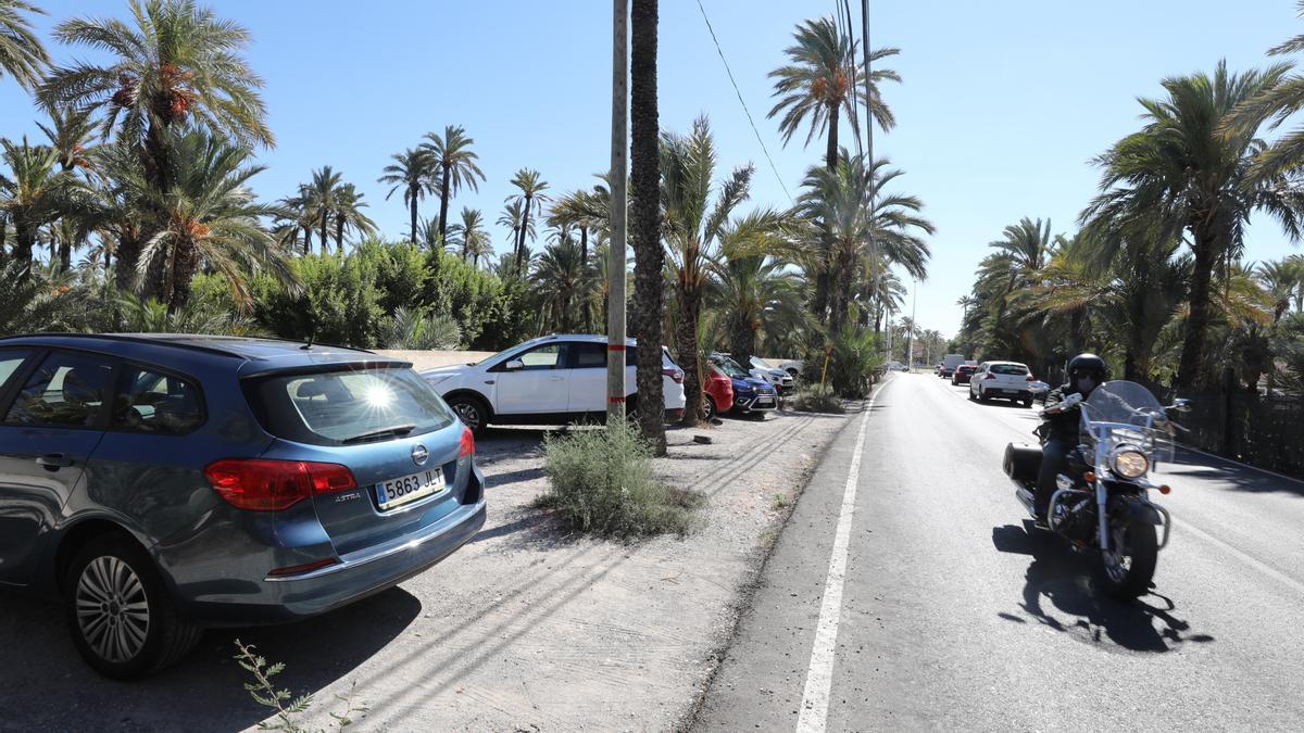 Vehículos estacionados entre palmeras en varios puntos del camino del Pantano, cerca de la estación de Renfe.