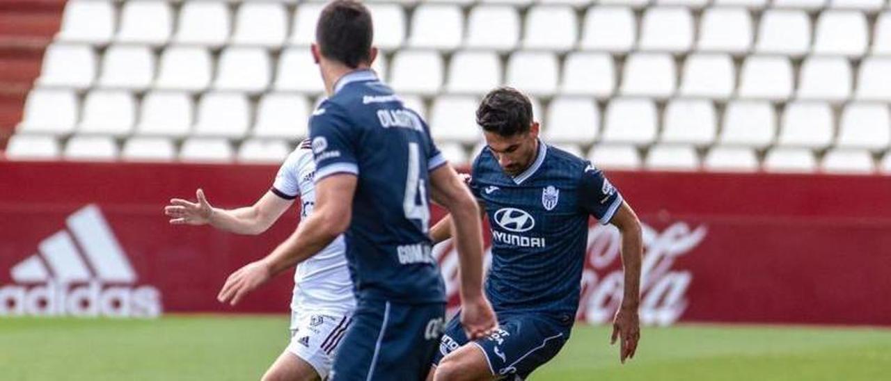 Alfonso protege el balón ante la presión de un futbolista del Albacete.