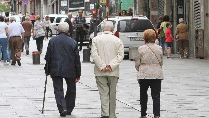 Tres personas mayores, paseando por la calle en Ourense. // I.O.