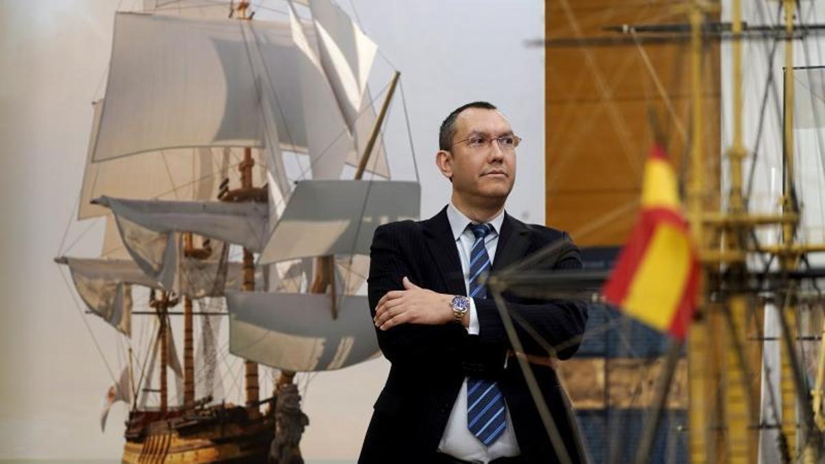 Rodrigo Pérez, profesor de la Escuela de Ingenieros Navales y comisario de la exposición, con una recreación del San Juan Nepomuceno a su espalda.