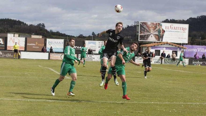 Robert disputa un balón de cabeza con un jugador rival.