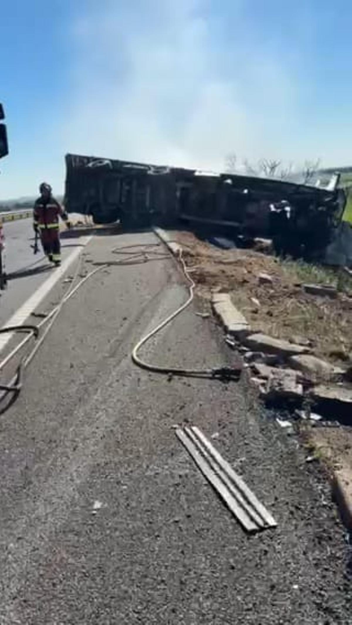 El camión, volcado entre el arcén y la cuneta, tras el accidente.