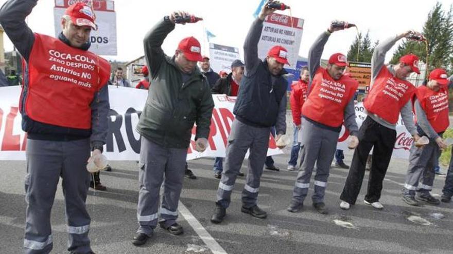 Trabajadores de la fábrica de Asturbega escancian Coca-Cola durante un corte de carretera, ayer, en Colloto.
