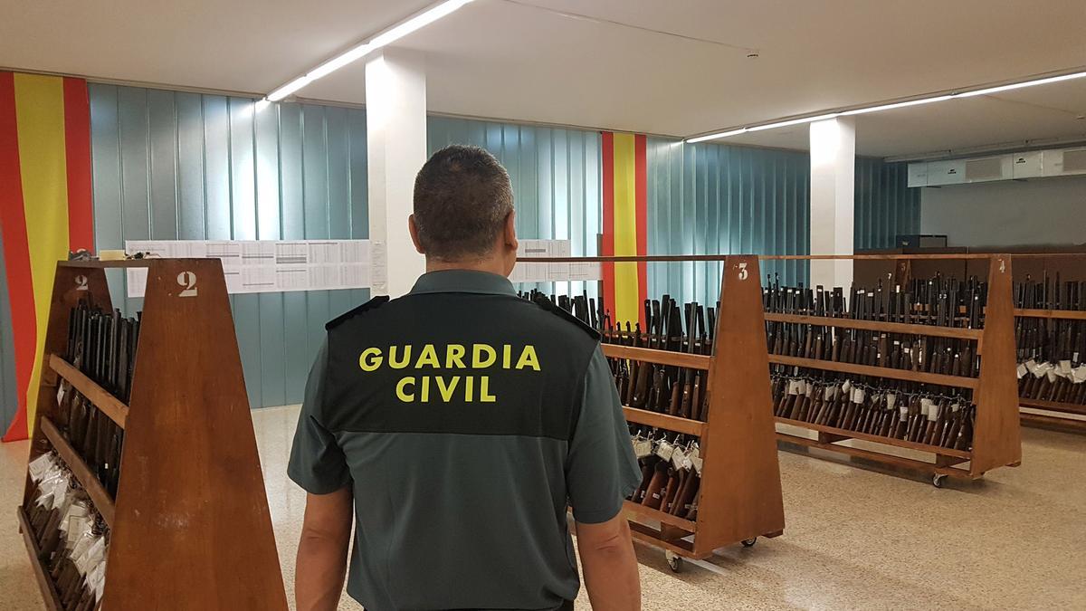 Un agente de la Guardia Civil custodia los lotes de armas