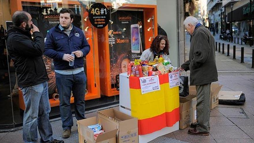 Falange recoge alimentos en Oviedo con polémica y entre un amplio despliegue policial