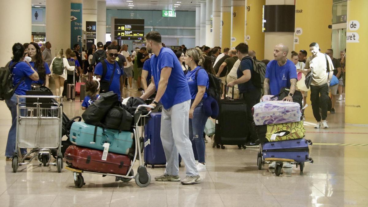 Passatgers carregats amb maletes a la zona d'arribades a l'aeroport de Barcelona.