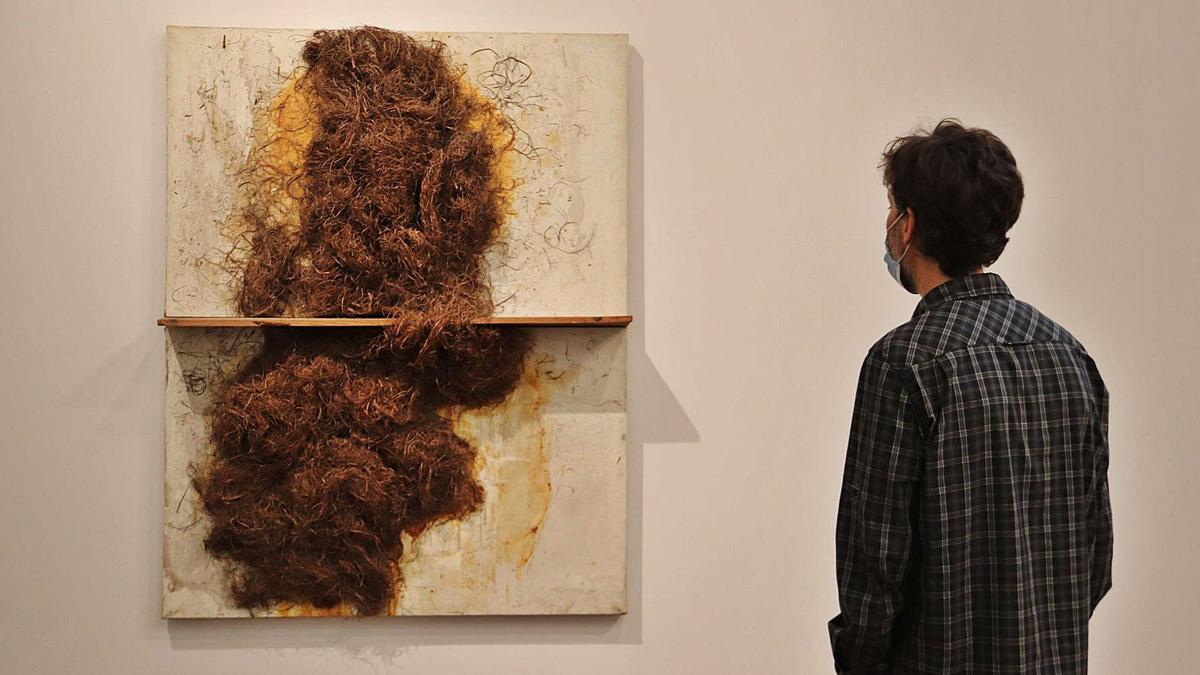 Un visitant contempla una de les obres exposades a la mostra «Tàpies. La realitat en primer pla» | MARIA ASMARAT/ACN