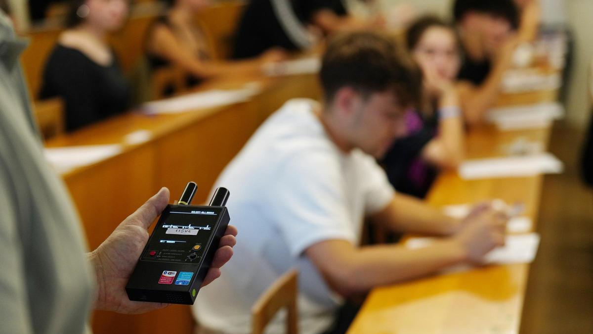 Una profesora revisa que no haya dispositivos electrónicos escondidos durante la PAU 2026 en una facultad.