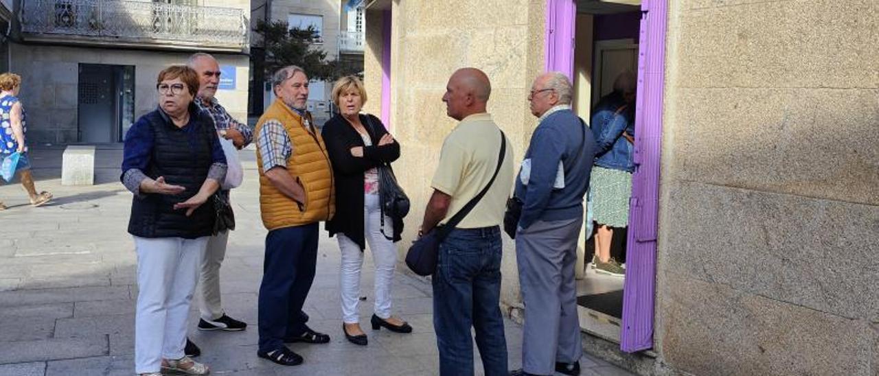 Un grupo de vecinos, ayer, intentando reservar viajes del Imserso en Cangas.   | FDV