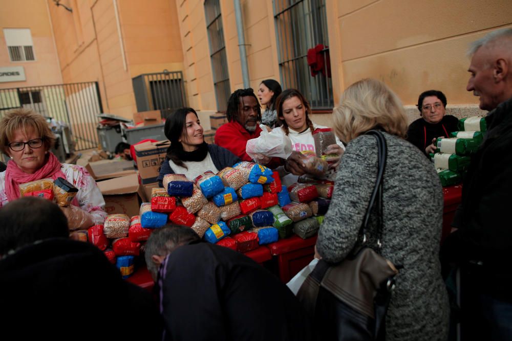 Volunteers distribute food to people during a ...