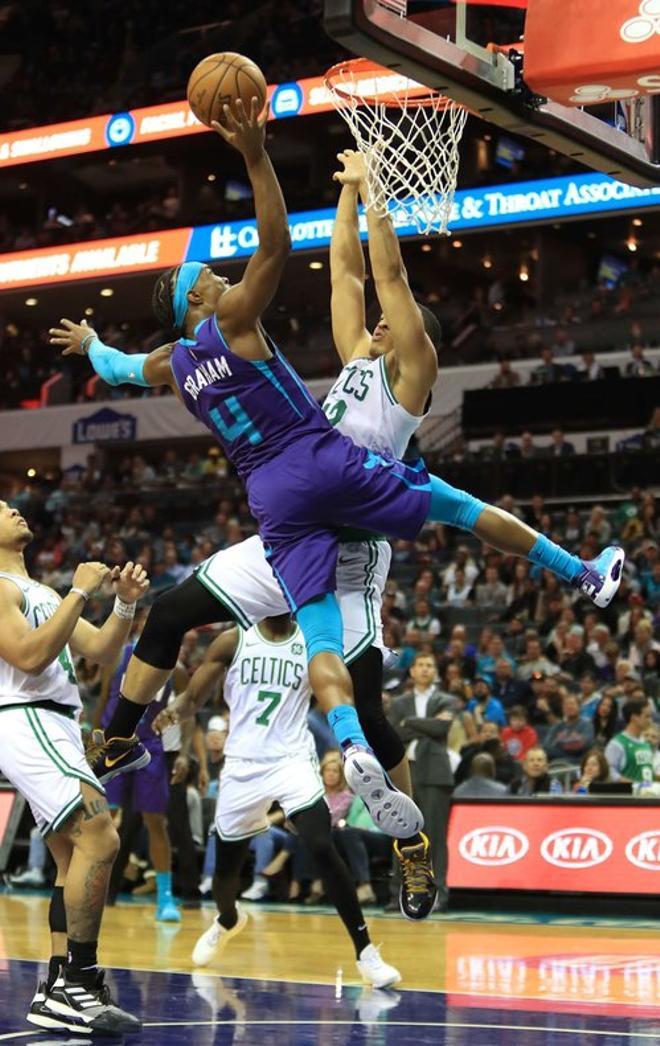 Devonte Graham # 4 de los Charlotte Hornets lanza a  canasta contra Grant Williams # 12 de los Boston Celtics durante su juego en Spectrum Cente.