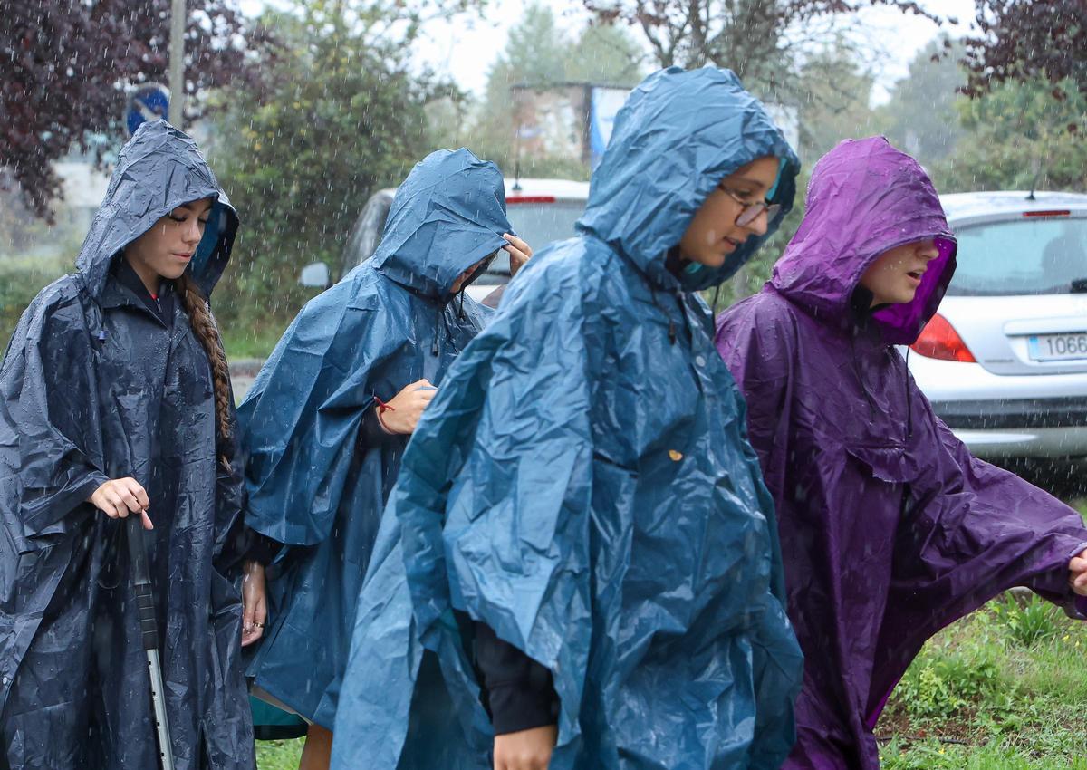 Personas cubriéndose de la lluvia con chubasqueros.