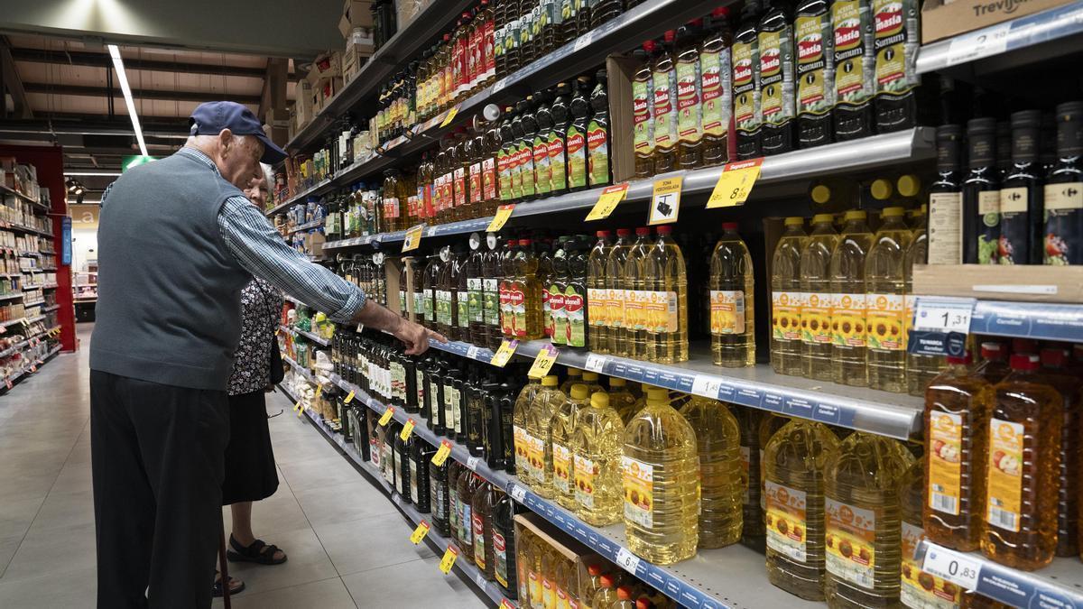 Dos jubilados en la zona de aceites de un supermercado de Barcelona.