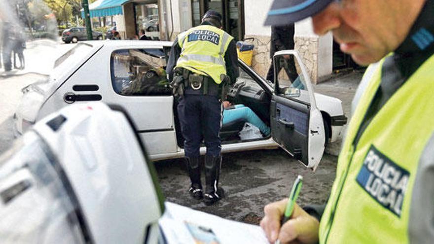 Un agente de la Policía Local rellena un boletín de denuncia en un control de tráfico.