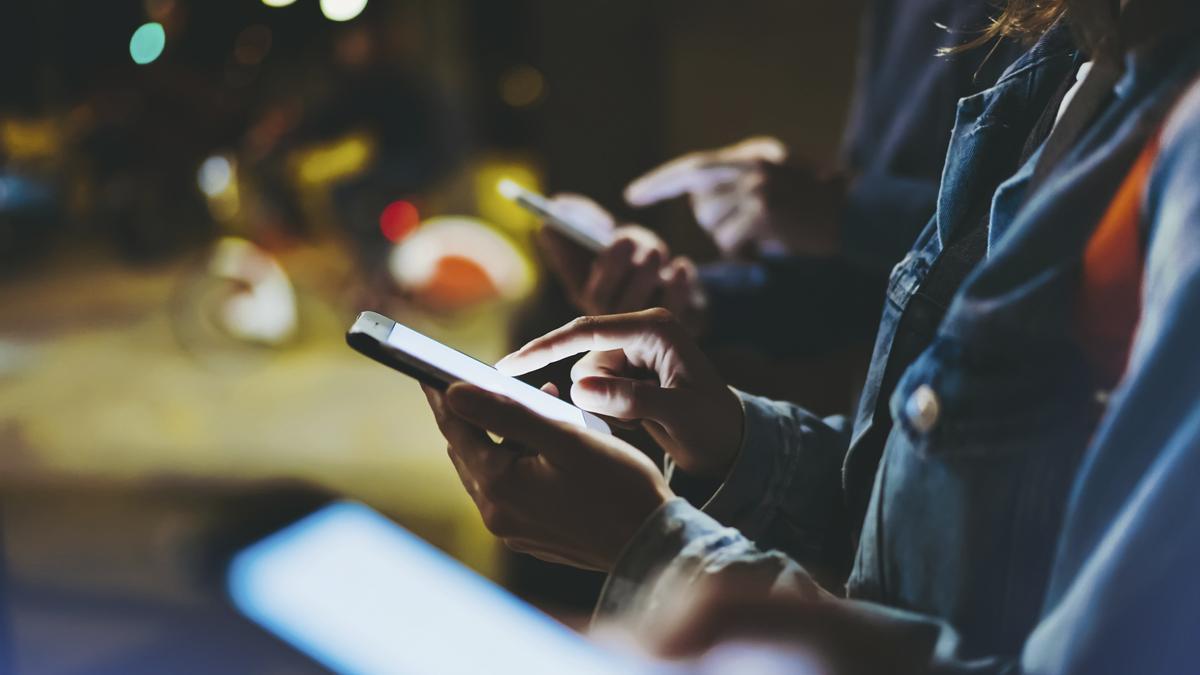 Un grupo de personas navegando por la red a través de su smartphone.