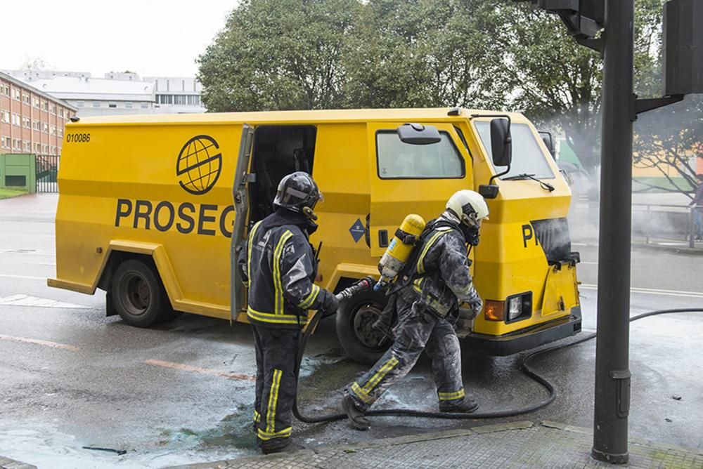 Bomberos trabajan en la extinción de un incendio en un camión blindado