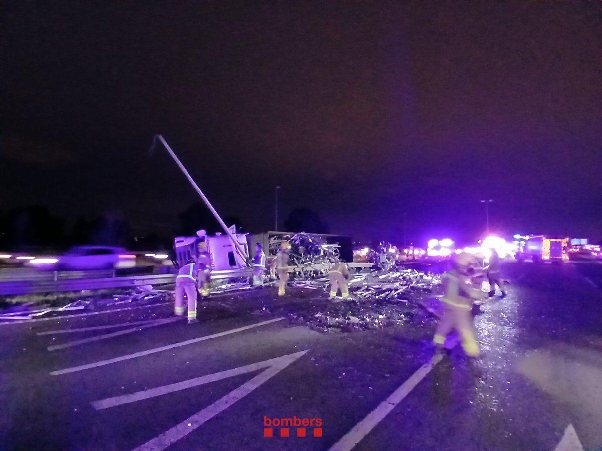 Bomberos trabajan en el accidente de un camión en la AP-7, en El Papiol, este lunes.