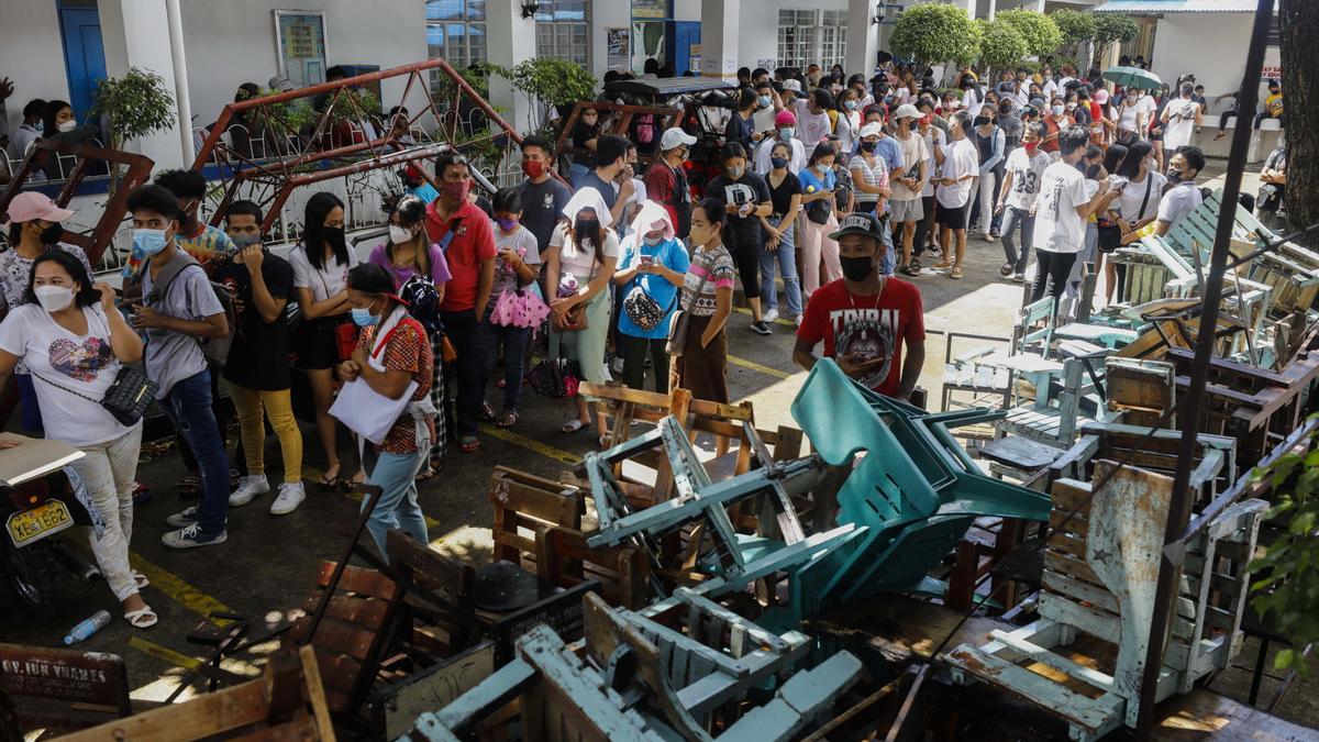 Ciudadanos filipinos hacen cola para votar.