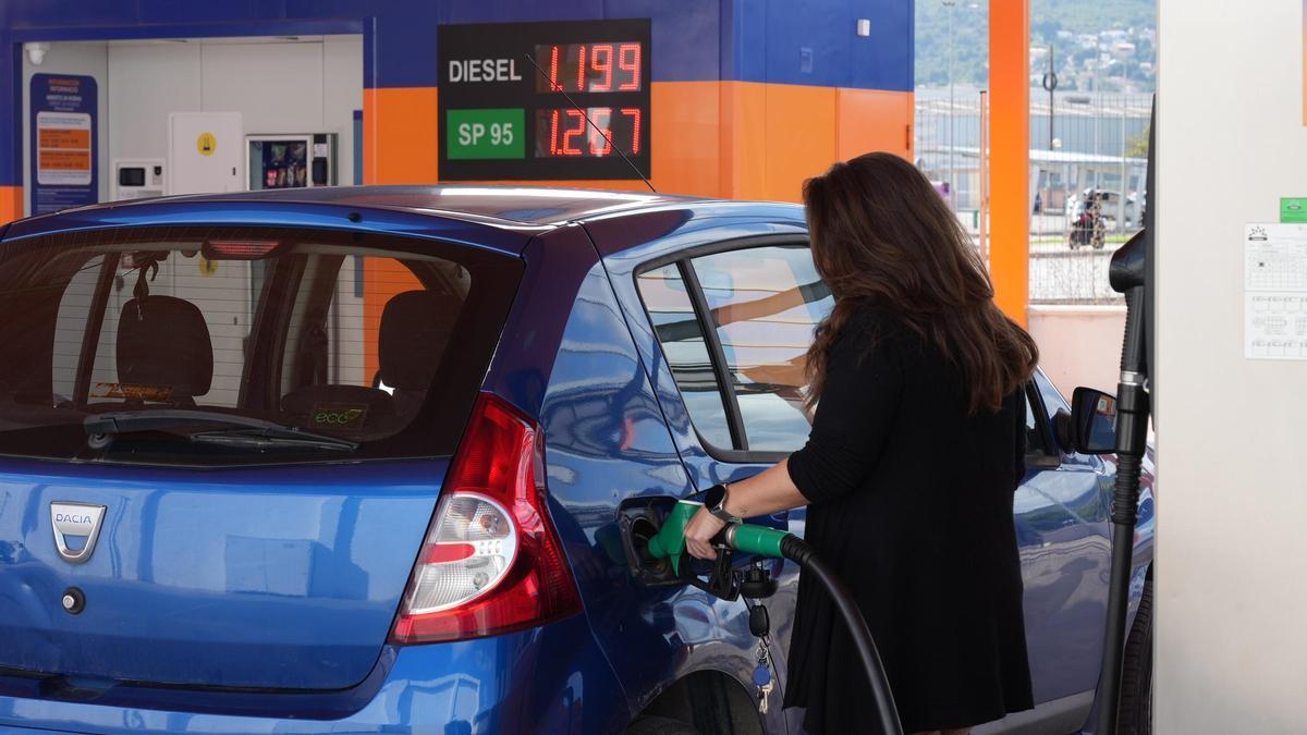 Una mujer llena el depósito en una gasolinera 'low cost' de Castellón.