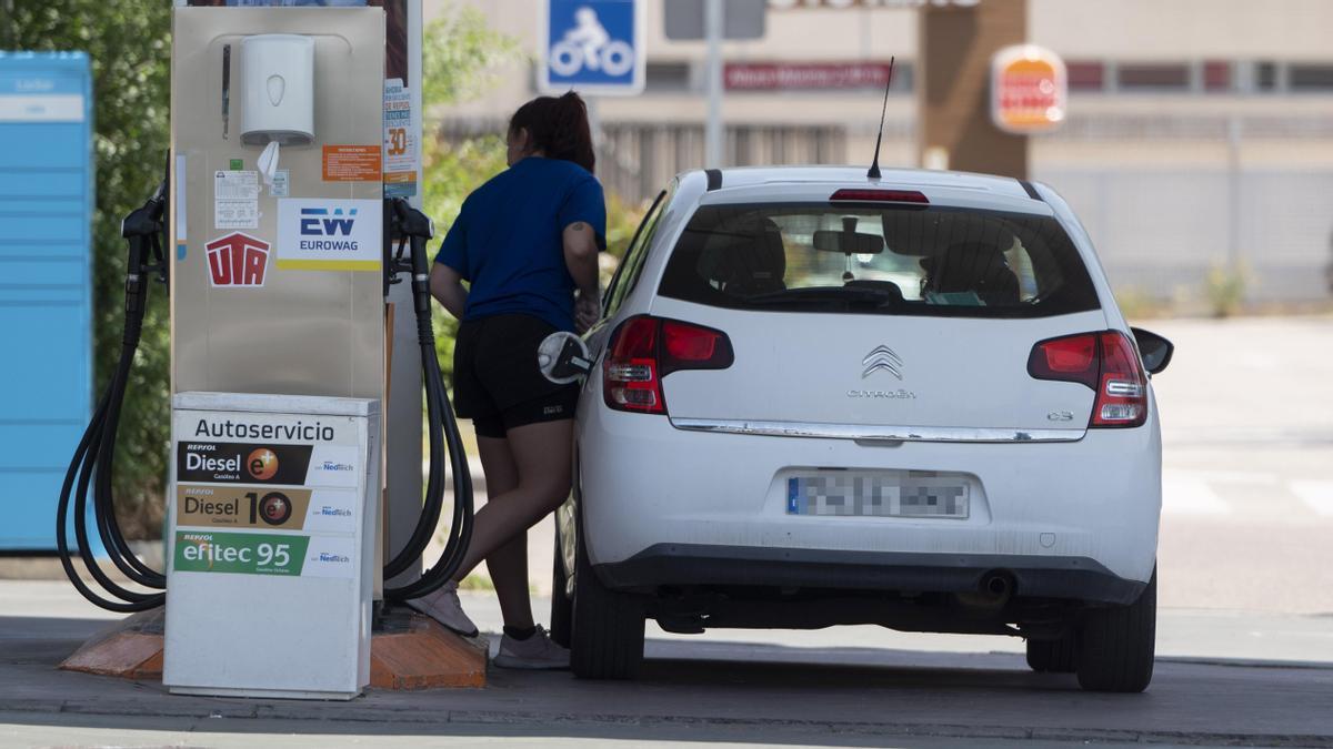 Una mujer reposta en una gasolinera