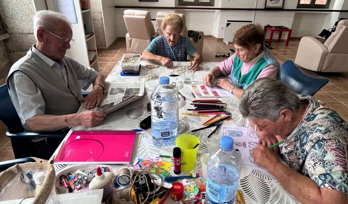 Usuarios de la casa de Augalada (Coristanco) realizando actividades y leyendo la prensa / colaxe