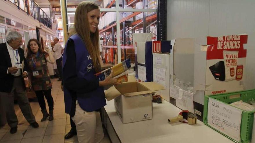 María Castro prepara una de las cajas con alimentos que se donarán a personas necesitadas. // Adrián Irago