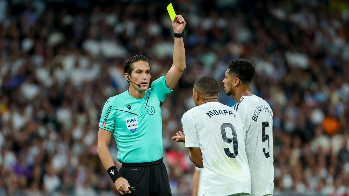 El árbitro José Luis Munuera Montero muestra la tarjeta amarilla al delantero francés del Real Madrid Kylian Mbappé