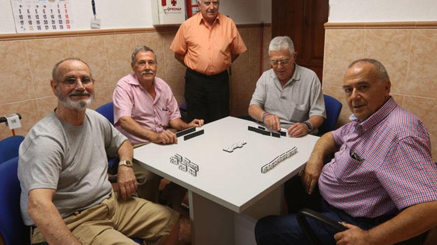 Miguel Rojas de Oña, Juan Enamorado Martín, Francisco Andrade y  Rafael Giral Pacheco juegan al dominó en la sede de la asociación.