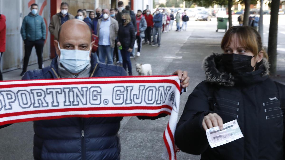 Octavio de la Villa, con una bufanda del Sporting, y Mónica Lorences, con una entrada para el partido de Lugo, ayer, en El Molinón.