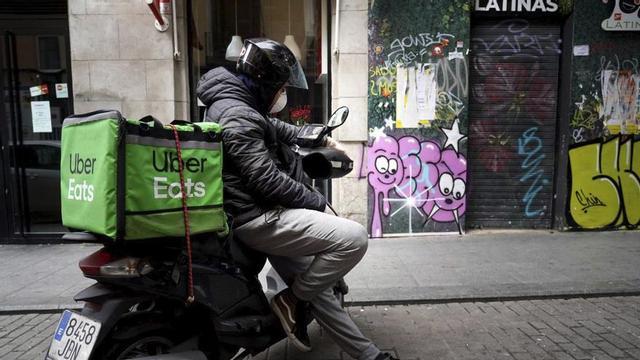 Un repartidor d’Uber Eats en moto, a Madrid.