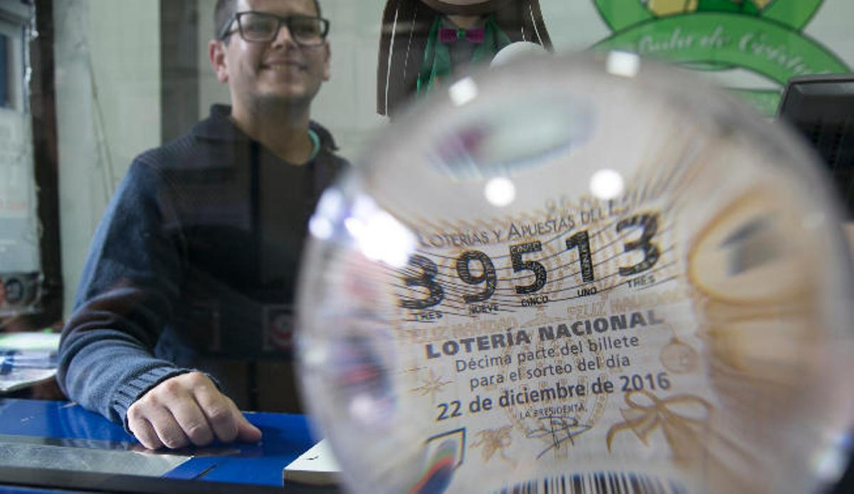Doramas Pérez Rodríguez, titular de la administración La Bola de Cristal de Pedro Infinito, con el número premiado reflejado en la bola que da nombre al negocio.