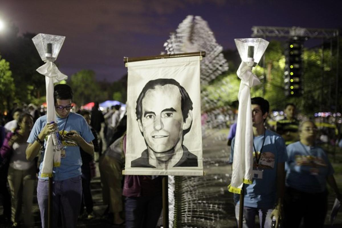 Catholic faithful participate in a procession commemorating the 25th anniversary of the death of Father Ignacio Ellacuria (pictured on banner) along with five other Jesuit priests and two employees, who were killed by government military forces during the Salvadoran civil war, at the Central American University in San Salvador (UCA) November 15, 2014. REUTERS/Jose Cabezas (EL SALVADOR - Tags: RELIGION ANNIVERSARY OBITUARY CONFLICT)