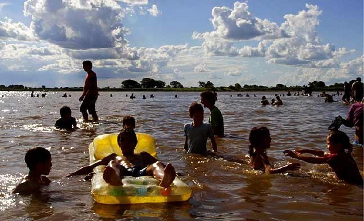 Un grupo de niños juega en el río Paraguay en Asunción (Paraguay).