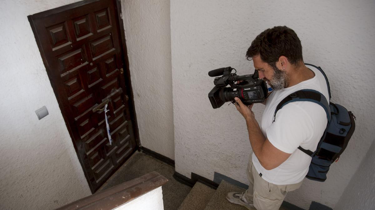Un reportero de televisión toma imágenes de la puerta de la vivienda donde ocurrieron los hechos.