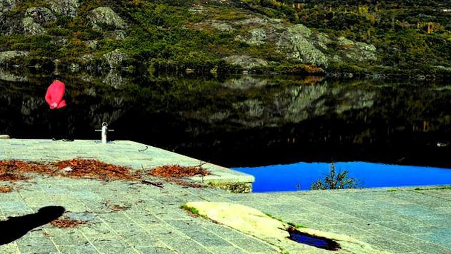 Una persona observa el agua del Lago de Sanabria.