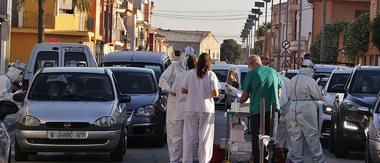 Dos colas de vehículos aguardan las pruebas PCR tras un brote, en una imagen de archivo. | VICENT M. PASTOR