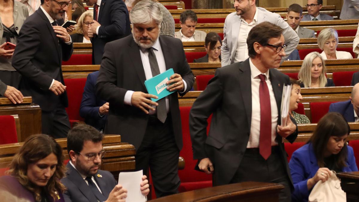 El president del grup parlamentari de Junts, Albert Batet, passant a l'hemicicle pel cantó del president de la Generalitat, Pere Aragonès, i el líder del PSC, Salvador Illa, allunyant-se