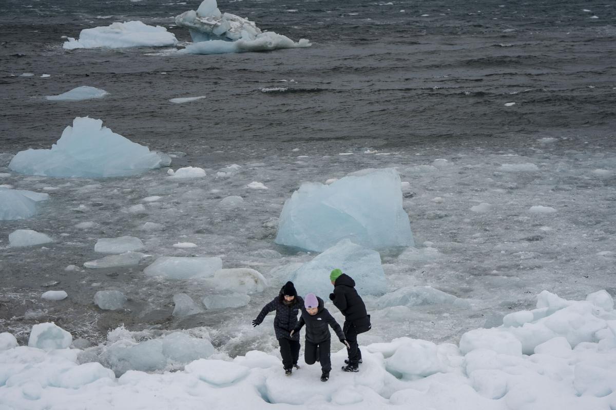  La gente camina cerca del hielo amontonado en el fiordo de Nuuk, en Nuuk